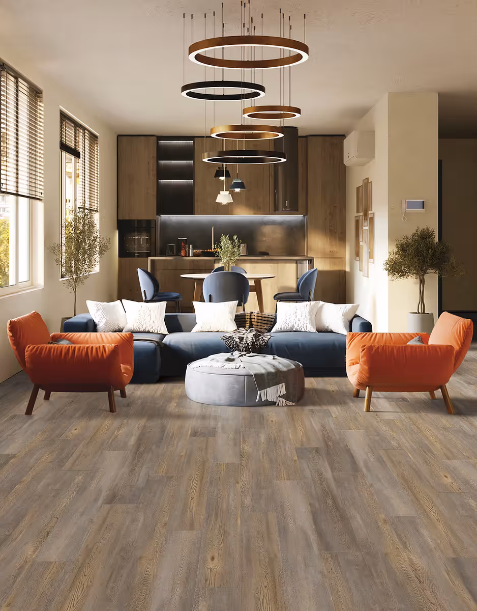 A living room seating area with navy blue couch, orange armchairs, and brown textured LUX luxury vinyl plank flooring.